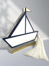 Γούρι design καραβάκι από plexiglass με navy περίγραμμα, χρυσή σημαία και λευκή φούντα – αυτοστηριζόμενο