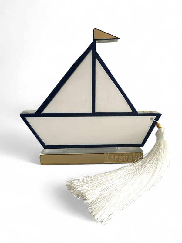 Γούρι design καραβάκι από plexiglass με navy περίγραμμα, χρυσή σημαία και λευκή φούντα – αυτοστηριζόμενο