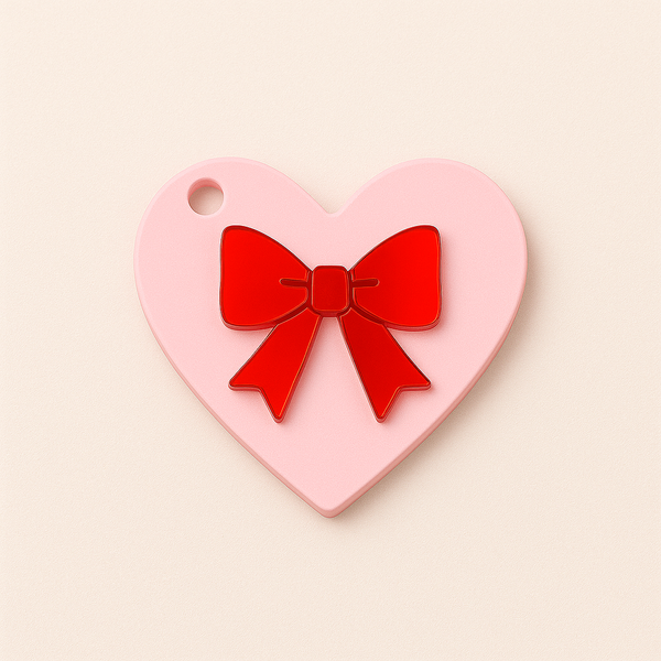 Heart-shaped plexiglass charm with red mirror appliqué bow, 8cm, for bag charm or keychain.