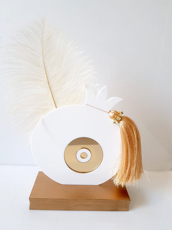 Χειροποίητο επιτραπέζιο γούρι ρόδι από plexiglass με χρυσό mirror μάτι, φτερό και φούντα με στρας, σε ξύλινη βάση, διαστάσεων 17×13 cm