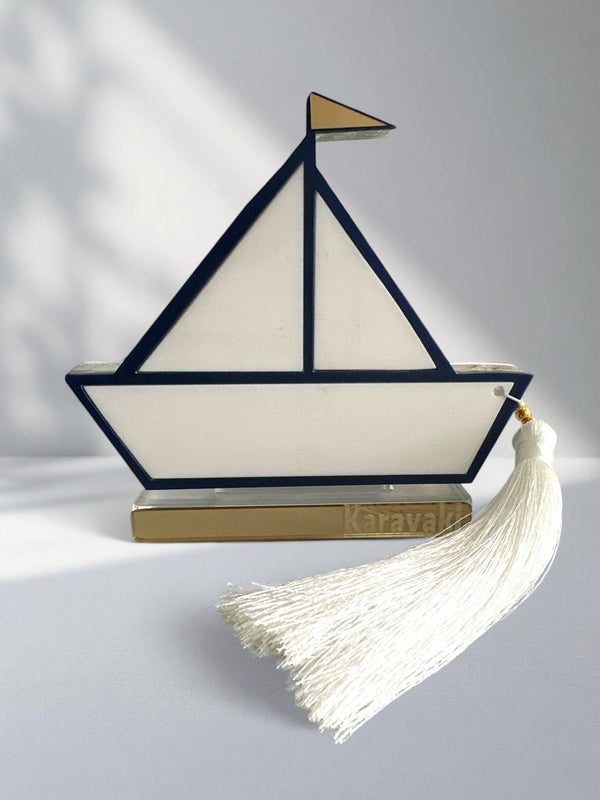 Γούρι design καραβάκι από plexiglass με navy περίγραμμα, χρυσή σημαία και λευκή φούντα – αυτοστηριζόμενο
