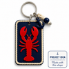 Project Idea: Ναυτικό μπρελόκ με ορθογώνια βάση από navy blue πλεξιγκλάς, εκρού σχοινί περιμετρικά και κόκκινο Coral Lobster από πλεξιγκλάς ως διακοσμητικό στοιχείο. Παράδειγμα δημιουργίας με το laser cut shape της So Cute Cut.