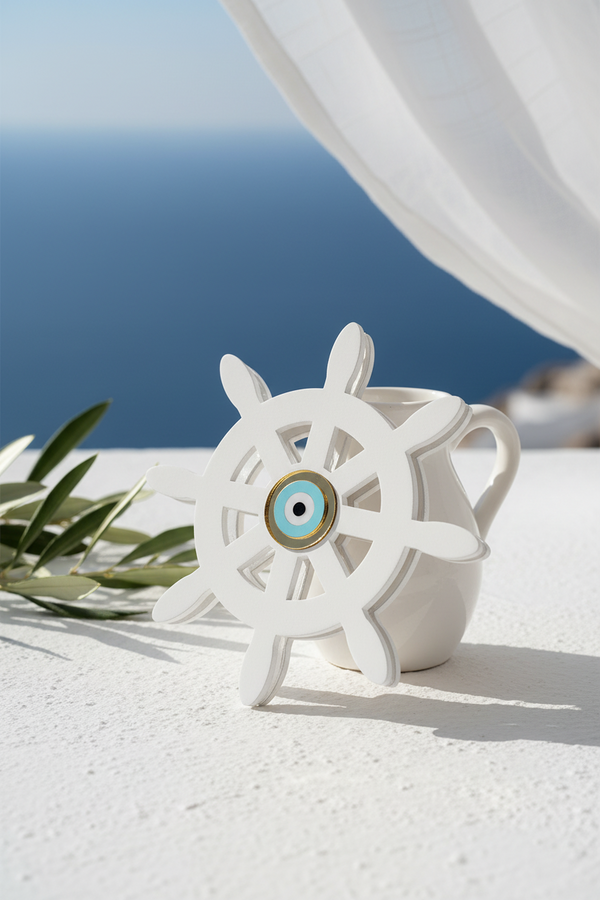 White plexiglass ship's wheel with a blue evil eye on a white surface with ocean view