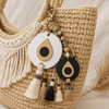 Evil Eye Circle bag charms από λευκό και μαύρο MDF με λεπτομέρεια από MDF οξιάς, διακοσμημένα με φούντες και χάντρες σε boho τσάντα | So Cute Cut