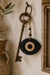 Evil Eye Sunburst από μαύρο MDF με λεπτομέρειες από MDF οξιάς κρεμασμένο σε vintage μπρούτζινο κλειδί με ξύλινες χάντρες σε boho διακόσμηση | So Cute Cut