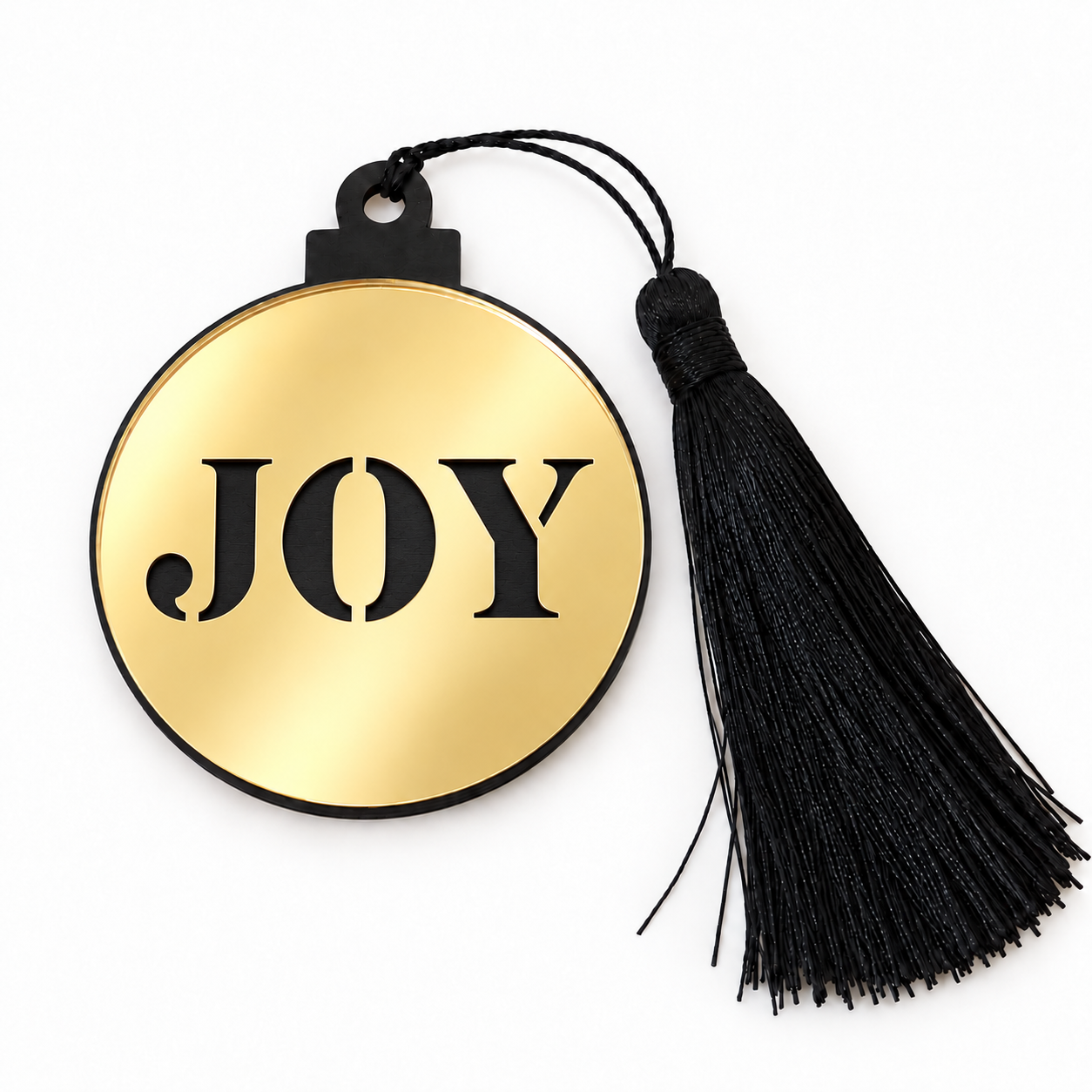 Γούρι μπάλα JOY με χρυσό καθρέφτη, γράμματα σε κοπή stencil που αποκαλύπτουν το μαύρο ξύλο και μαύρη φούντα, σε λευκό φόντο – So Cute Cut.